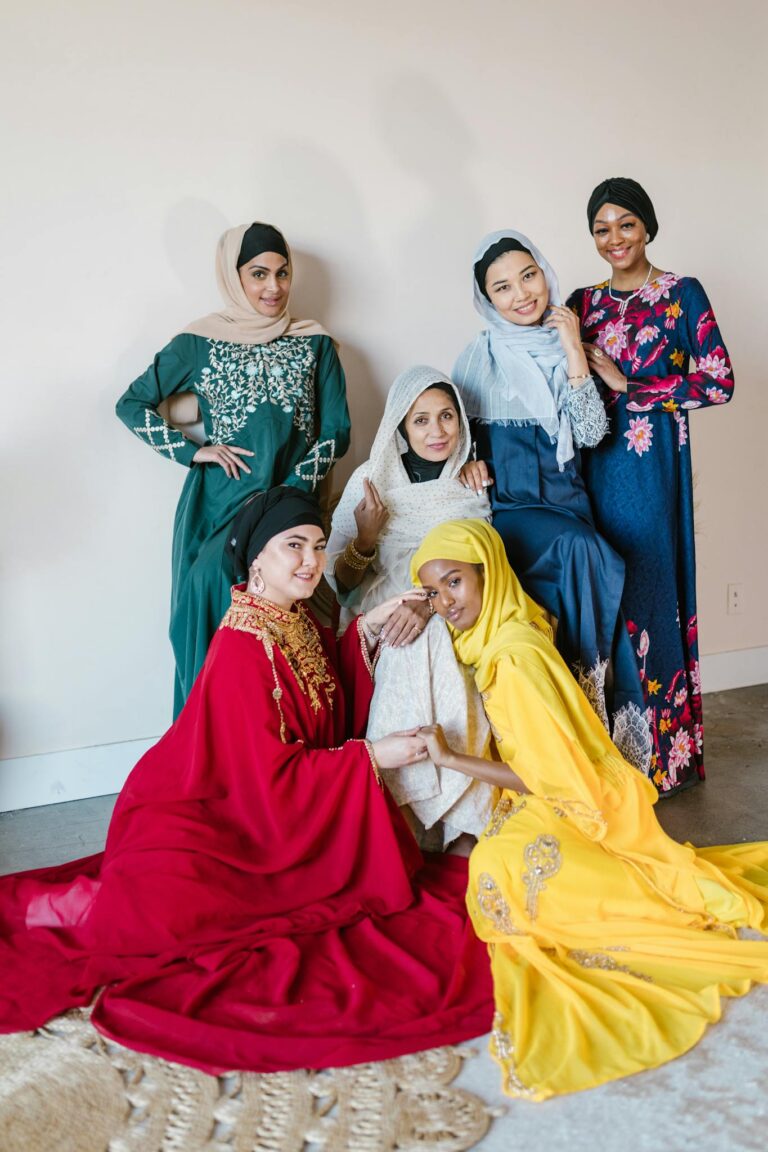 Woman in Green and White Sari Sitting Beside Woman in White Hijab